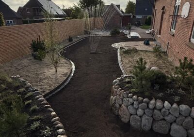 Gartenlandschaft mit Steinen, Pflanzen und Bewässerung, professionelle Gartengestaltung vom Gartenbau Th. Andresen Galabau.