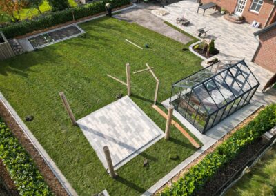 Grüner Garten mit Terrassen- und Gewächshaus, Landschaftsbau und Gartenpflege, hochwertige Gartenumgestaltung.